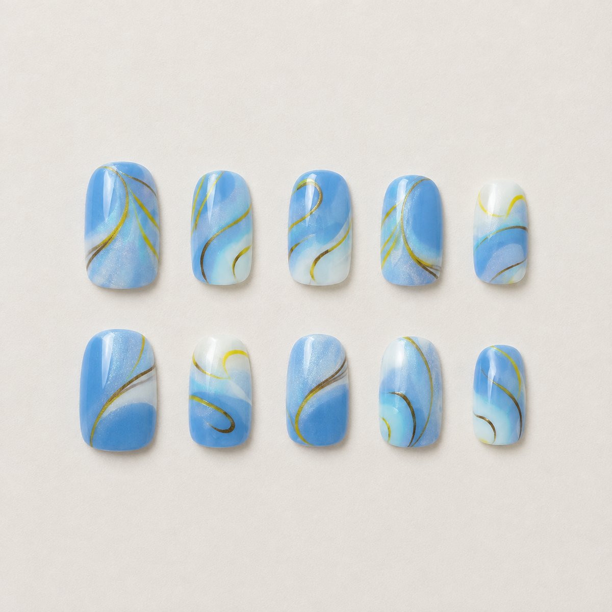 Golden Hour Waves blue and gold press-on nail set flat lay