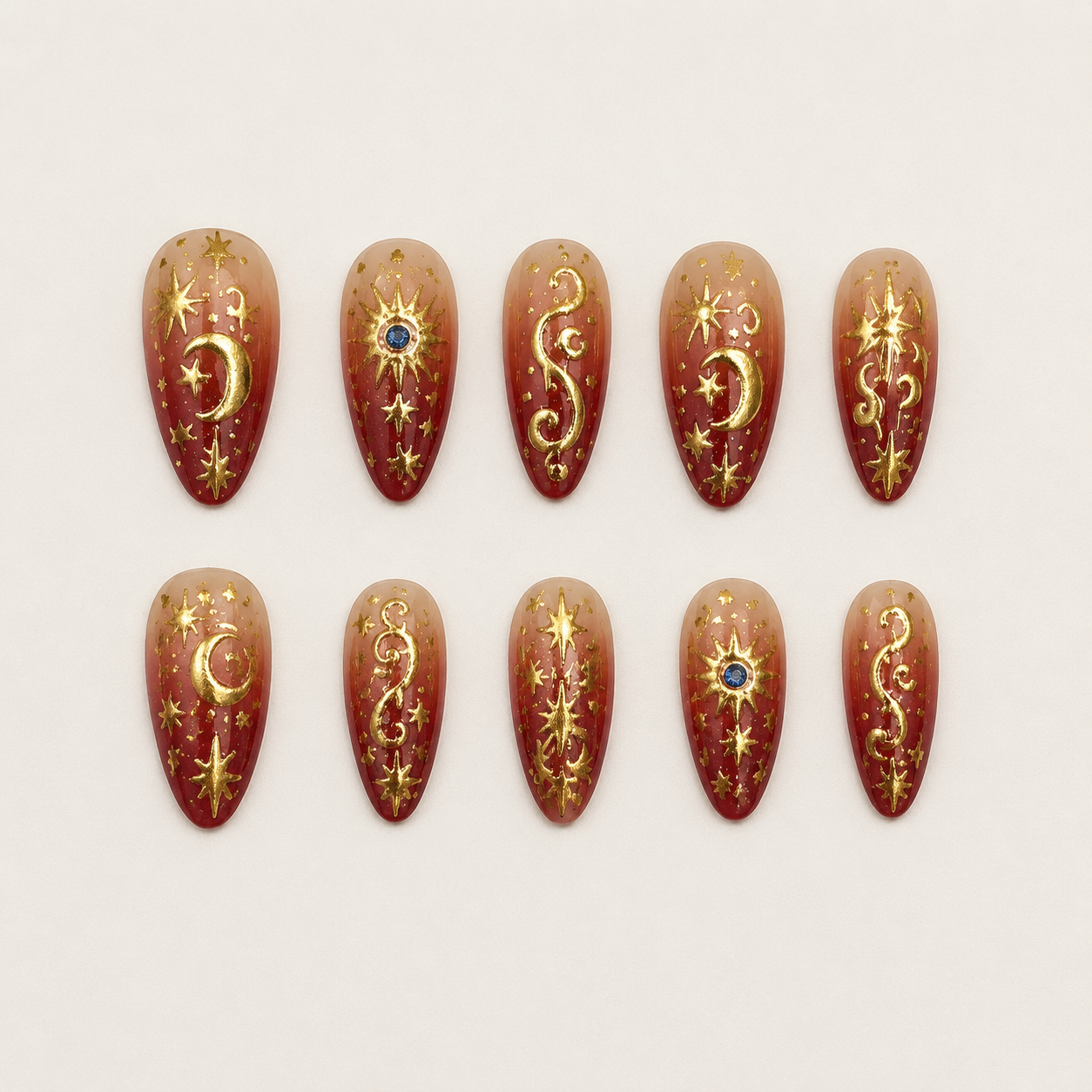 Cosmic Crimson & Metallic Gold Evil Eye Almond Press-On Nails flat lay